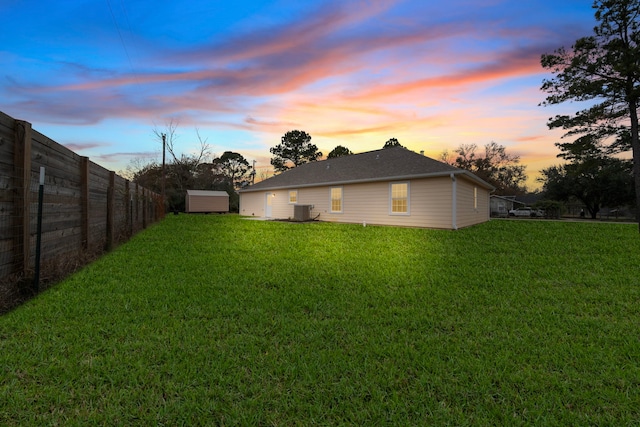 yard at dusk with cooling unit and a shed