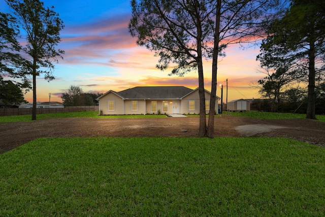 single story home with a yard and a storage unit