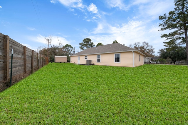 view of yard featuring central AC unit and a storage shed