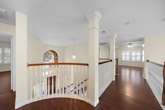 hallway featuring ornate columns and dark hardwood / wood-style flooring