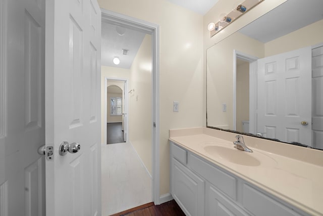 bathroom featuring vanity, wood-type flooring, and toilet