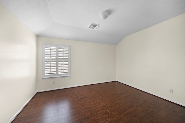 unfurnished room featuring lofted ceiling and dark hardwood / wood-style floors