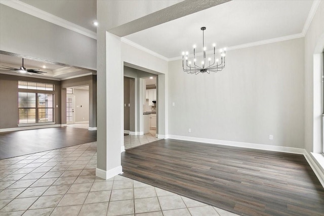 tiled spare room with ceiling fan with notable chandelier and ornamental molding