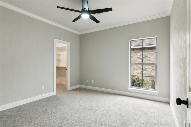 carpeted spare room with crown molding and ceiling fan