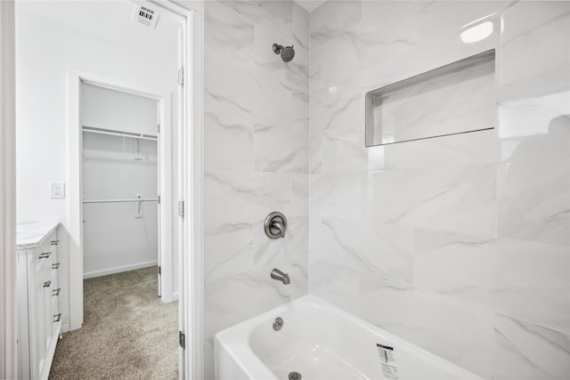 bathroom featuring tiled shower / bath and vanity