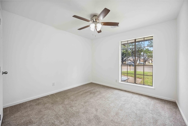 spare room featuring ceiling fan and carpet