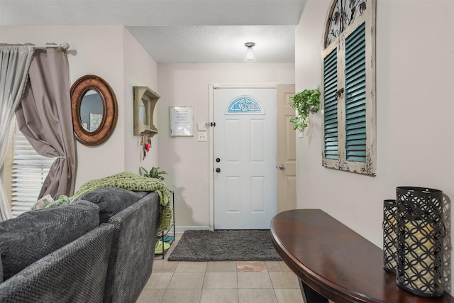 foyer featuring light tile patterned floors and a textured ceiling