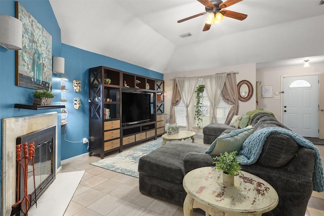 living room featuring vaulted ceiling, light tile patterned floors, and ceiling fan