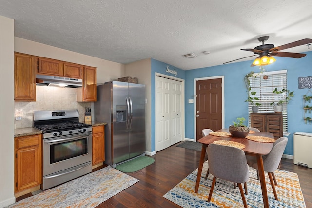 kitchen with stainless steel appliances, dark hardwood / wood-style flooring, a textured ceiling, and backsplash