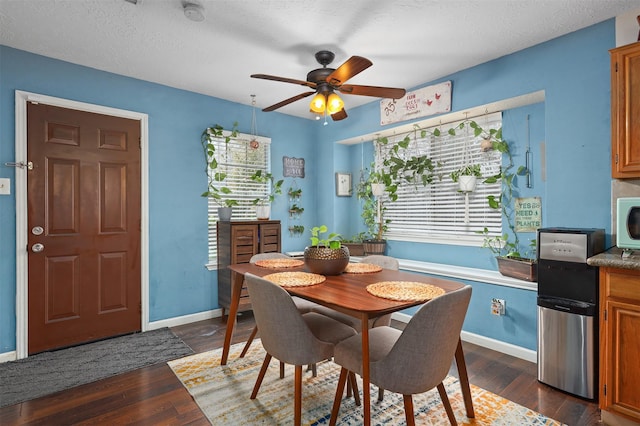 dining room featuring a textured ceiling, dark wood-type flooring, and ceiling fan