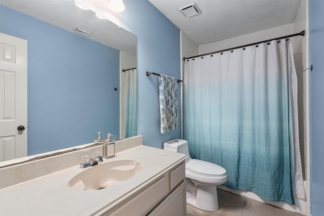 bathroom featuring tile patterned floors, vanity, toilet, and a textured ceiling