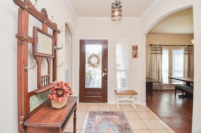 foyer featuring light tile patterned floors and ornamental molding