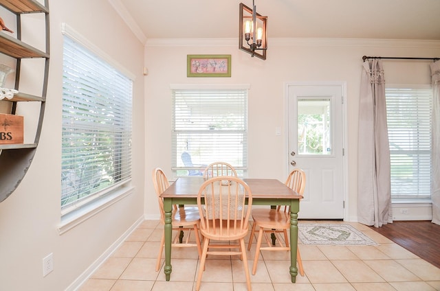 tiled dining room featuring crown molding and a chandelier