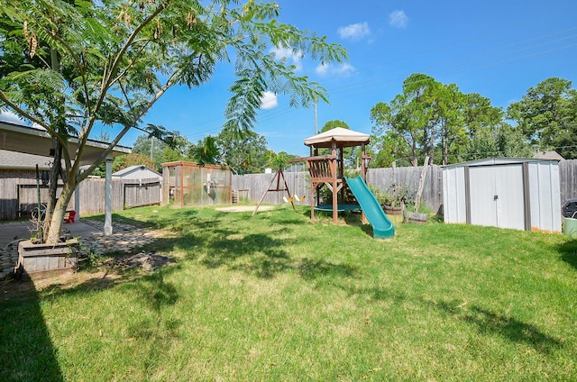 view of yard with a storage shed and a playground