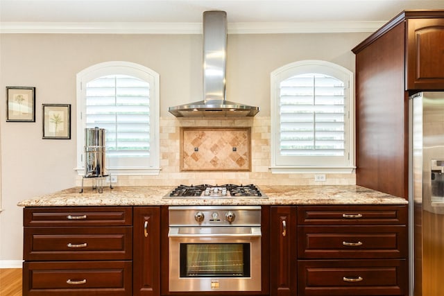 kitchen with stainless steel appliances, light stone countertops, decorative backsplash, and wall chimney exhaust hood