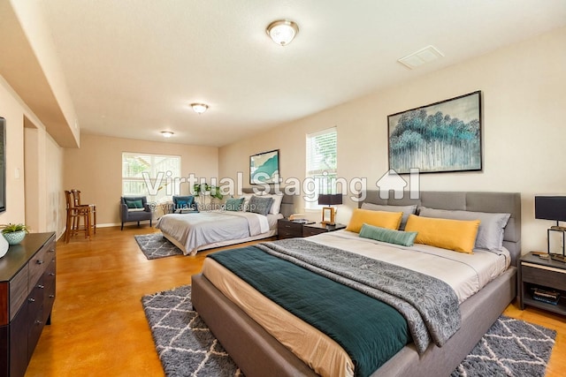 bedroom with multiple windows and light hardwood / wood-style flooring