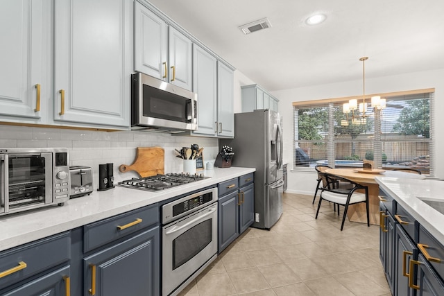 kitchen featuring an inviting chandelier, decorative light fixtures, light tile patterned floors, stainless steel appliances, and decorative backsplash