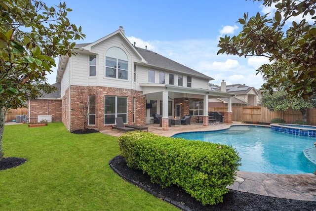 rear view of property with a swimming pool with hot tub, ceiling fan, a yard, central AC, and a patio area