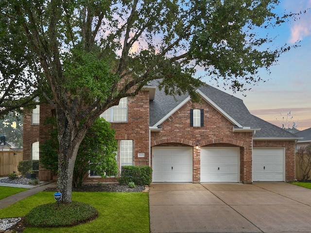 view of property featuring a garage and a yard