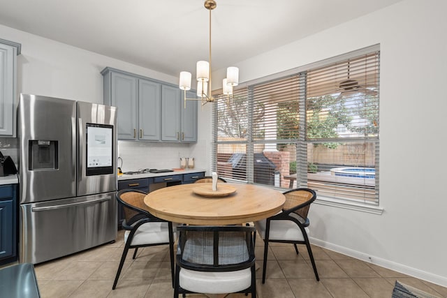 dining area with light tile patterned floors and an inviting chandelier