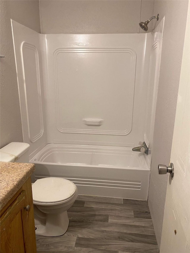 full bathroom featuring vanity, hardwood / wood-style flooring, shower / washtub combination, and toilet