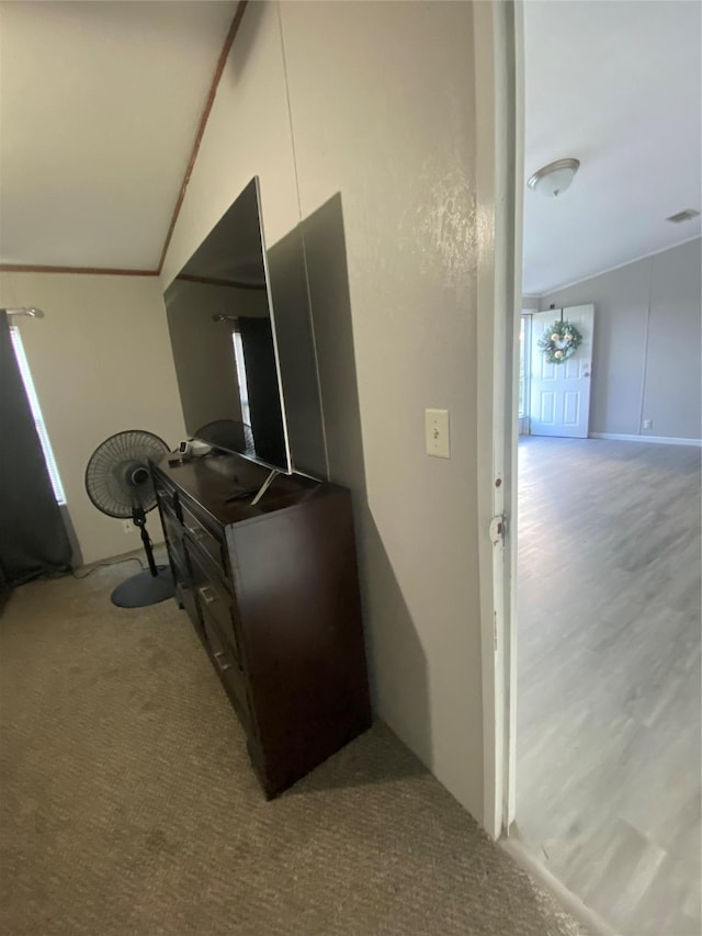 corridor with lofted ceiling and light carpet