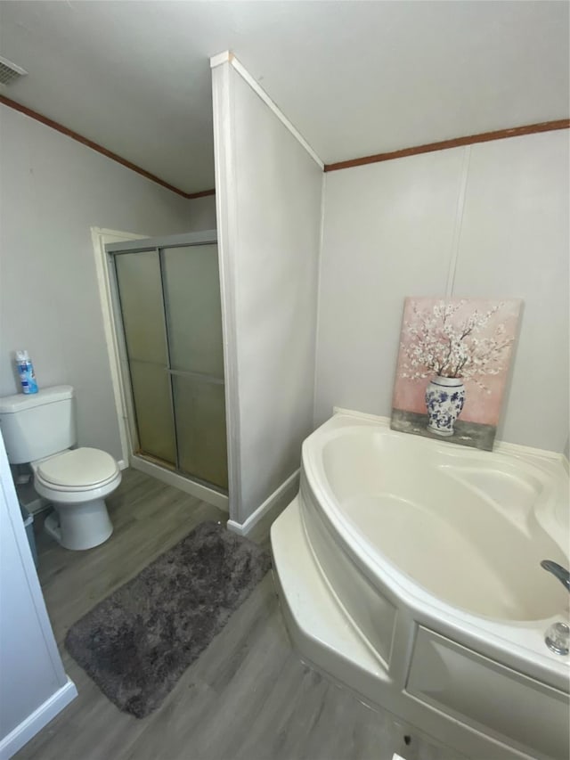 bathroom featuring hardwood / wood-style flooring, ornamental molding, toilet, and walk in shower