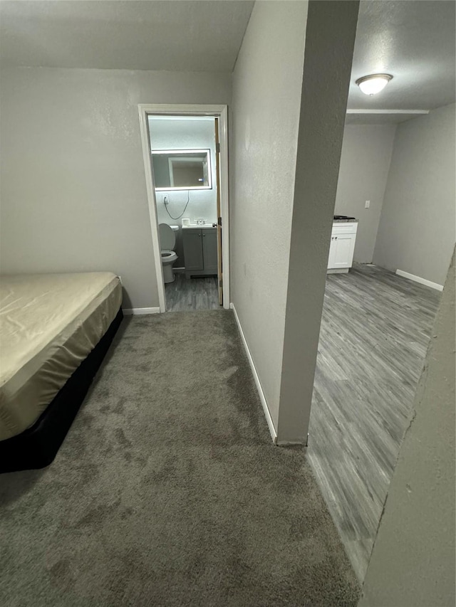 unfurnished bedroom featuring ensuite bathroom and carpet