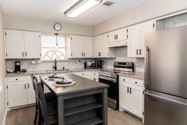 kitchen with appliances with stainless steel finishes, sink, and white cabinets