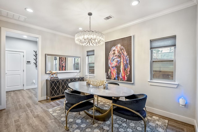 dining room with crown molding, a chandelier, and light hardwood / wood-style floors