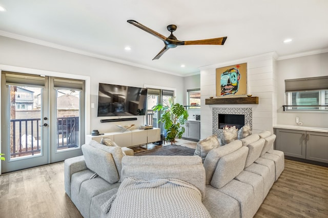 living room with french doors, crown molding, a healthy amount of sunlight, and light hardwood / wood-style flooring