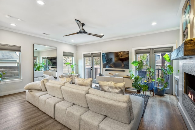 living room featuring crown molding, wood-type flooring, and ceiling fan