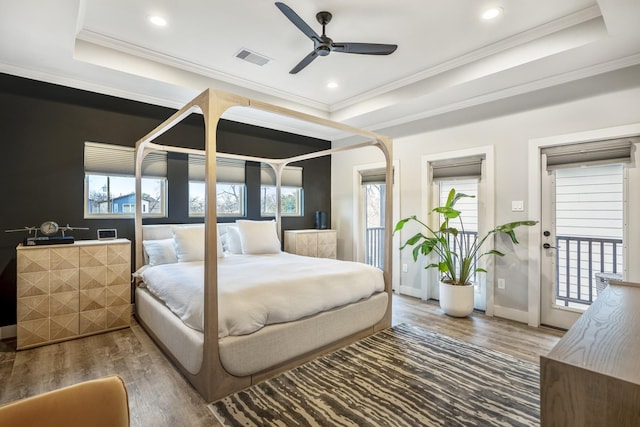 bedroom featuring ornamental molding, access to exterior, dark hardwood / wood-style flooring, and a tray ceiling