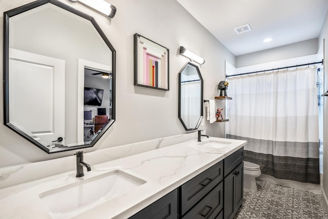 bathroom featuring vanity, tile patterned floors, and toilet