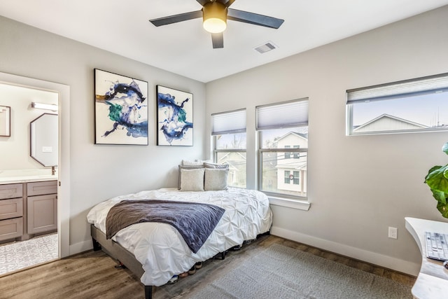 bedroom featuring multiple windows, connected bathroom, and light wood-type flooring