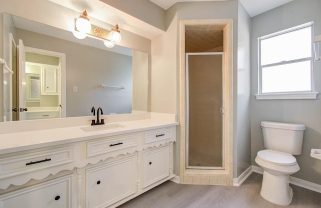 bathroom with an enclosed shower, hardwood / wood-style floors, vanity, and toilet