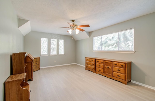 bonus room with ceiling fan, light hardwood / wood-style floors, a textured ceiling, and a wealth of natural light