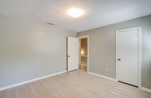 unfurnished bedroom featuring a textured ceiling and light hardwood / wood-style floors