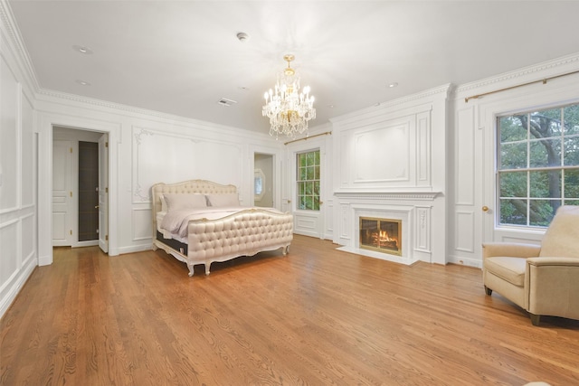 bedroom with crown molding, a chandelier, and light wood-type flooring