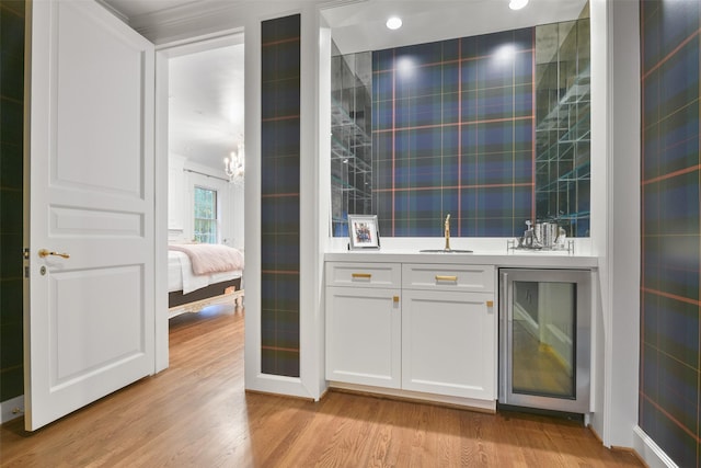 bar featuring wine cooler, white cabinetry, light hardwood / wood-style floors, and tile walls