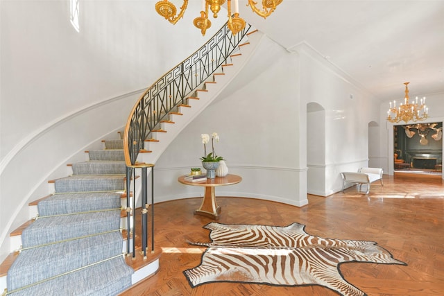 stairs featuring crown molding, parquet flooring, and a notable chandelier