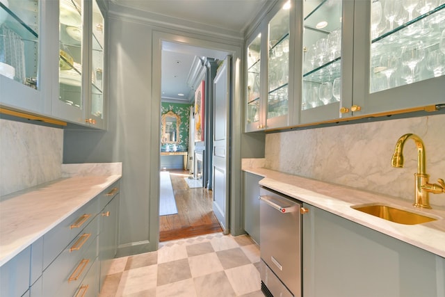 bar with a sink, tasteful backsplash, crown molding, wet bar, and light floors