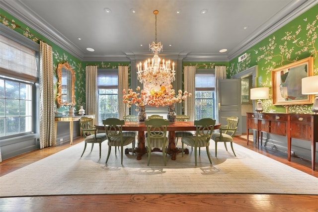 dining space with plenty of natural light, a notable chandelier, ornamental molding, and wallpapered walls