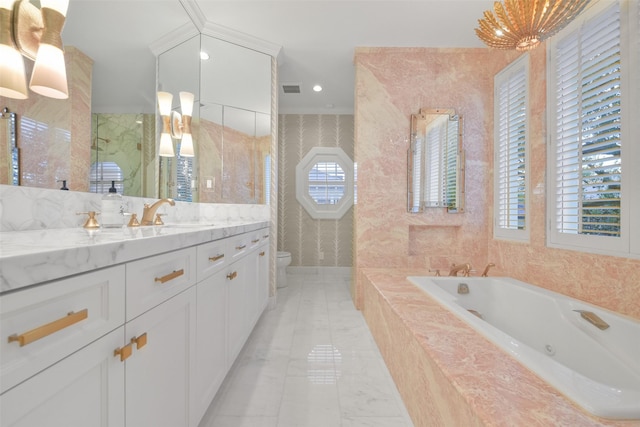 bathroom featuring vanity, tiled bath, and toilet