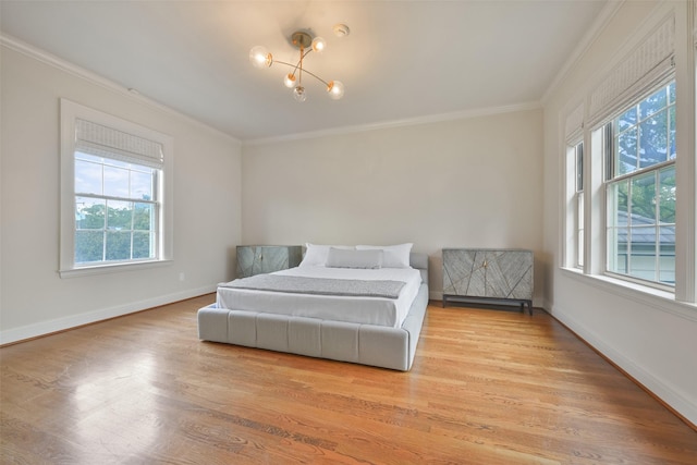 bedroom with ornamental molding, hardwood / wood-style floors, and a chandelier