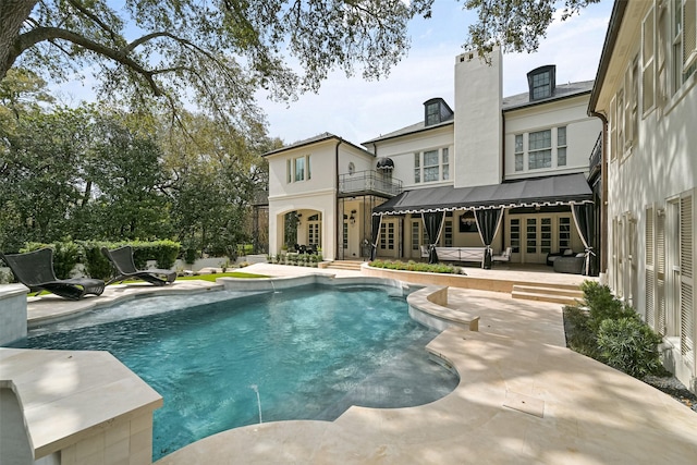 outdoor pool featuring french doors and a patio area