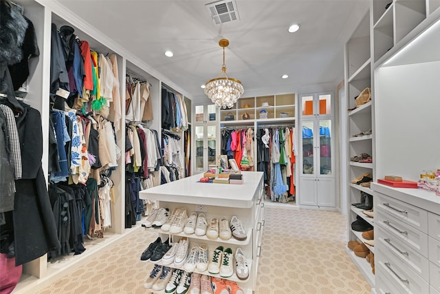 walk in closet featuring visible vents, carpet floors, and a chandelier