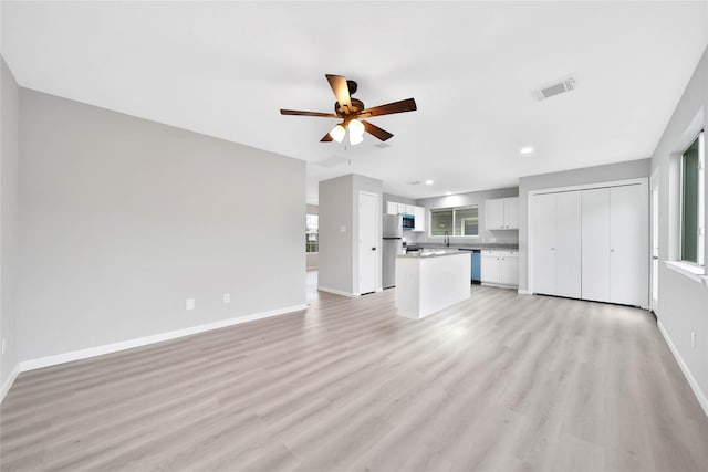 unfurnished living room featuring light hardwood / wood-style flooring and ceiling fan