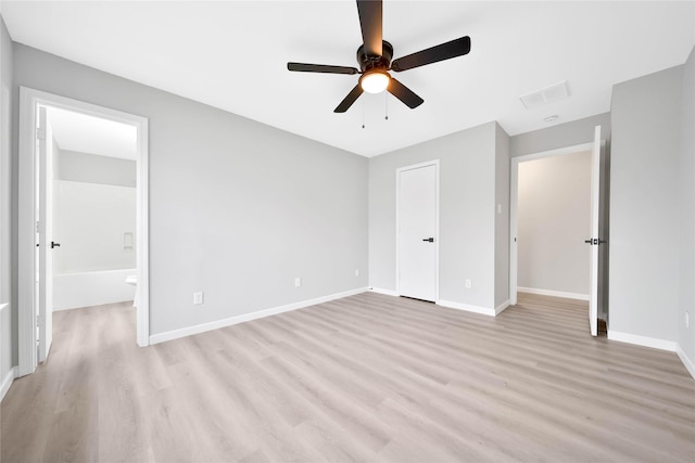 unfurnished bedroom featuring ensuite bath, ceiling fan, and light wood-type flooring