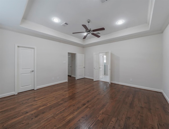 unfurnished bedroom featuring ceiling fan, ornamental molding, a tray ceiling, and dark hardwood / wood-style flooring